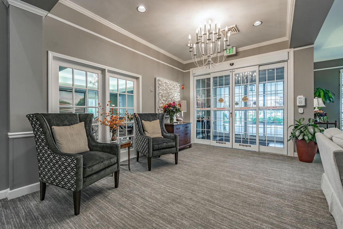 A well-decorated lobby featuring comfortable seating and a chandelier.