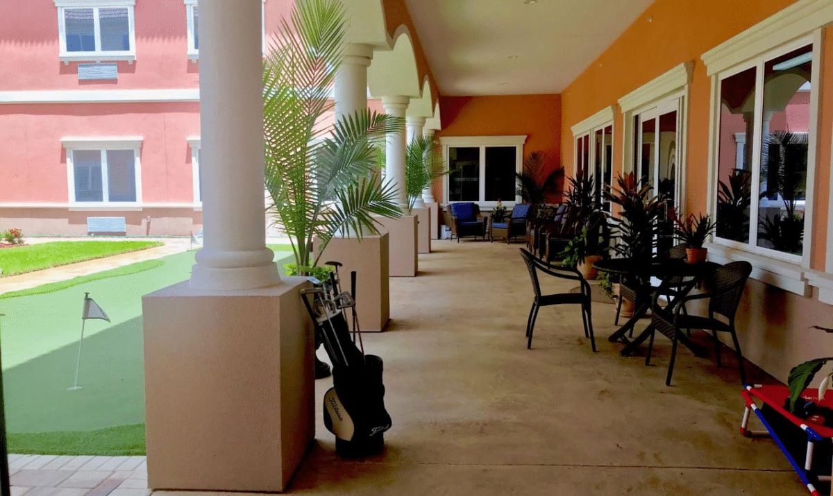 A veranda with outdoor seating and potted plants.