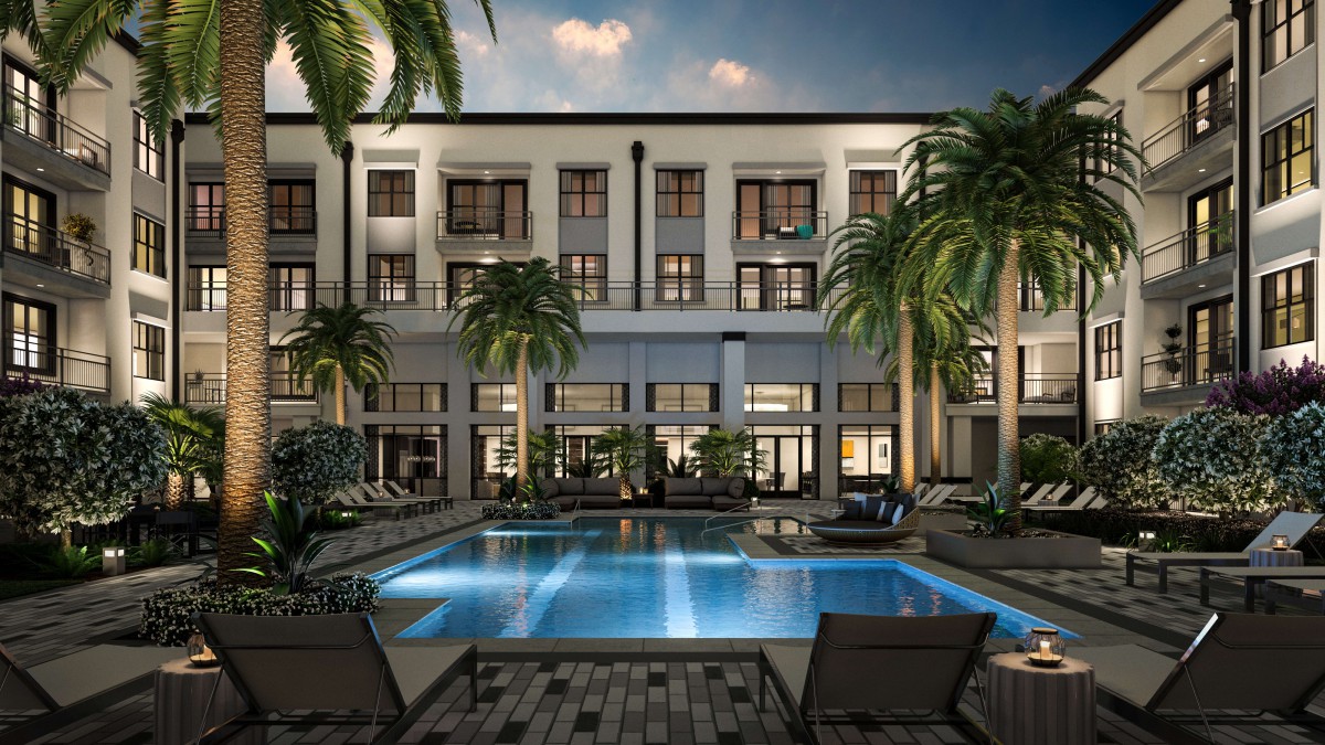 A luxurious hotel with a swimming pool surrounded by palm trees at night.