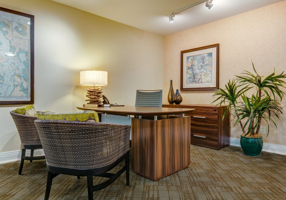 A modern office with a wooden desk, chairs, and decorative elements.