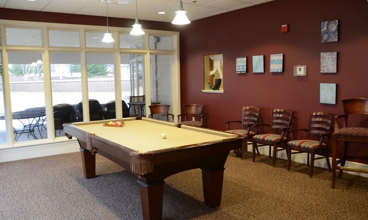 A cozy game room with a pool table and seating area.