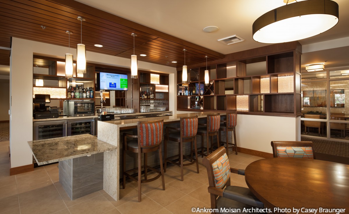 A modern bar interior with wooden decor and seating areas.
