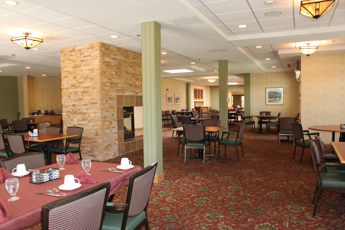 An elegantly designed dining area featuring neatly arranged tables and chairs, a cozy fireplace, and tasteful decor.