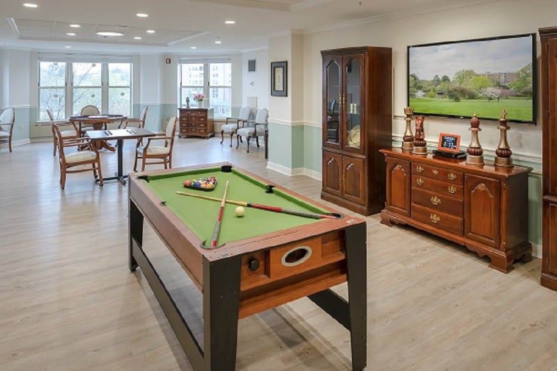 A well-appointed game room featuring a pool table and classic wooden furniture.