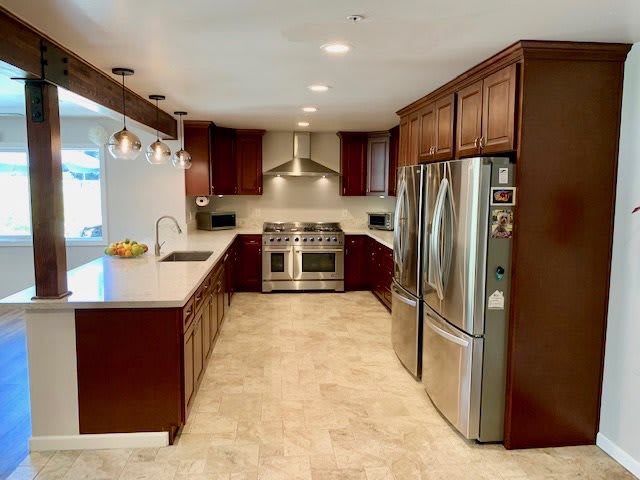 A modern kitchen with stainless steel appliances and wood cabinets.