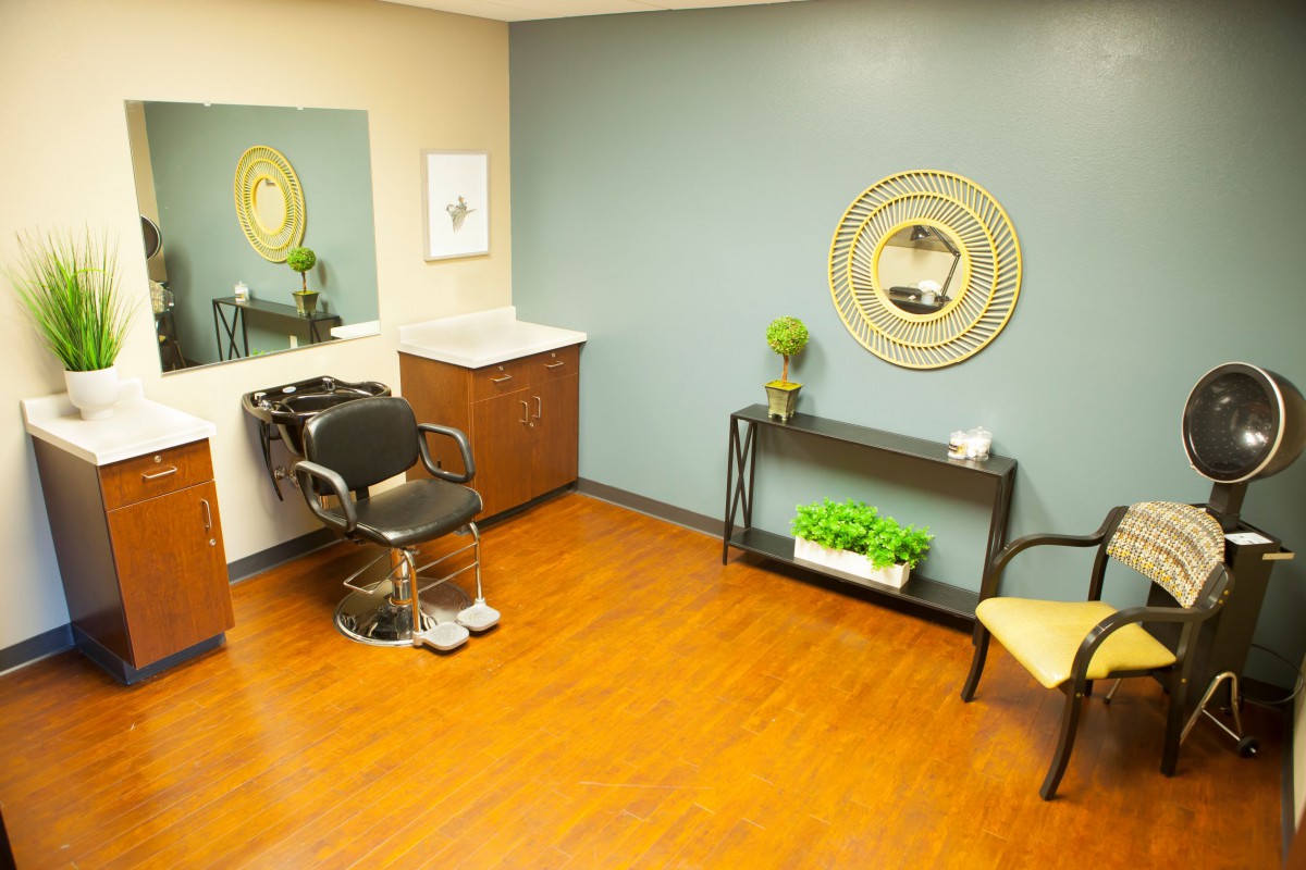A modern hair salon interior with a styling chair and elegant decor.