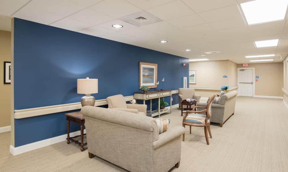 A modern lounge area with sofas, chairs, and a blue accent wall.