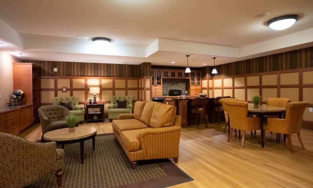 A cozy living room with an open kitchen layout, featuring comfortable sofas and warm lighting.
