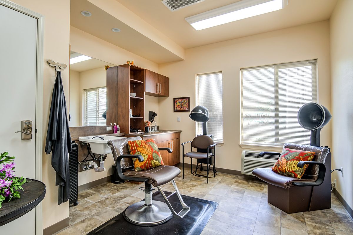 A modern hair salon interior with a comfortable styling chair and organized workspace.