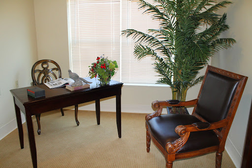A cozy office space featuring a desk, chair, decorative plant, and natural light from the window.
