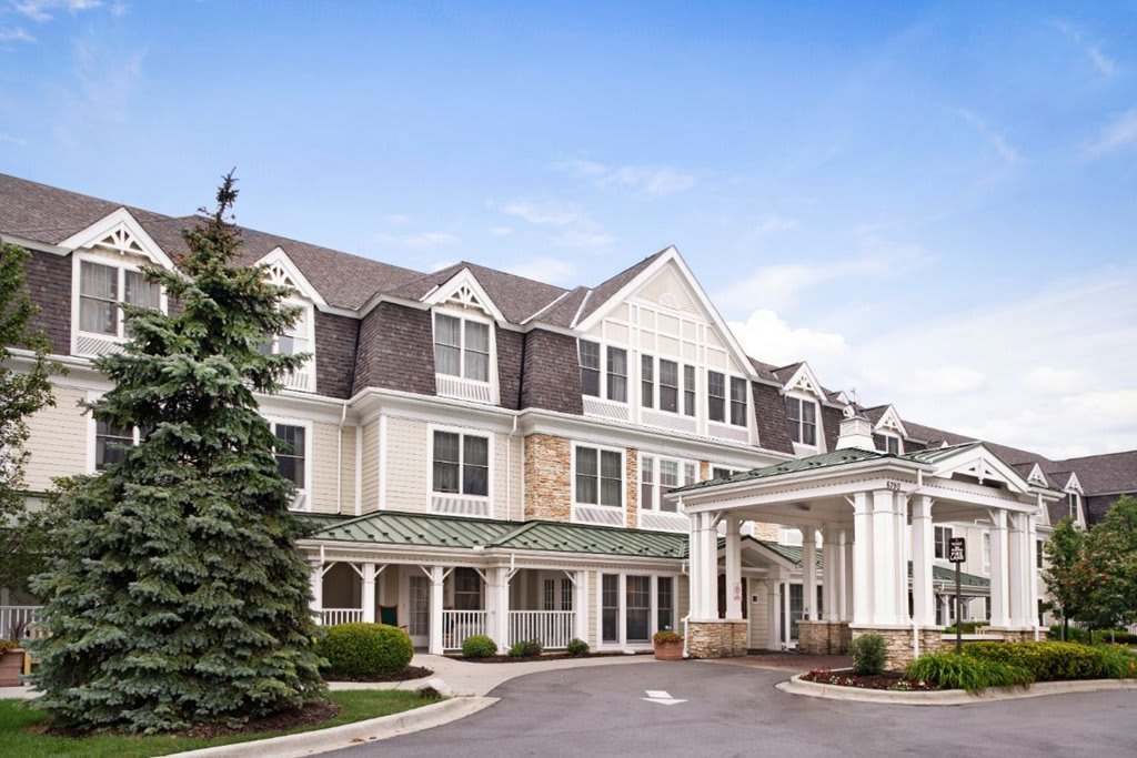 A view of a large hotel building with a grand entrance and well-maintained landscaping.