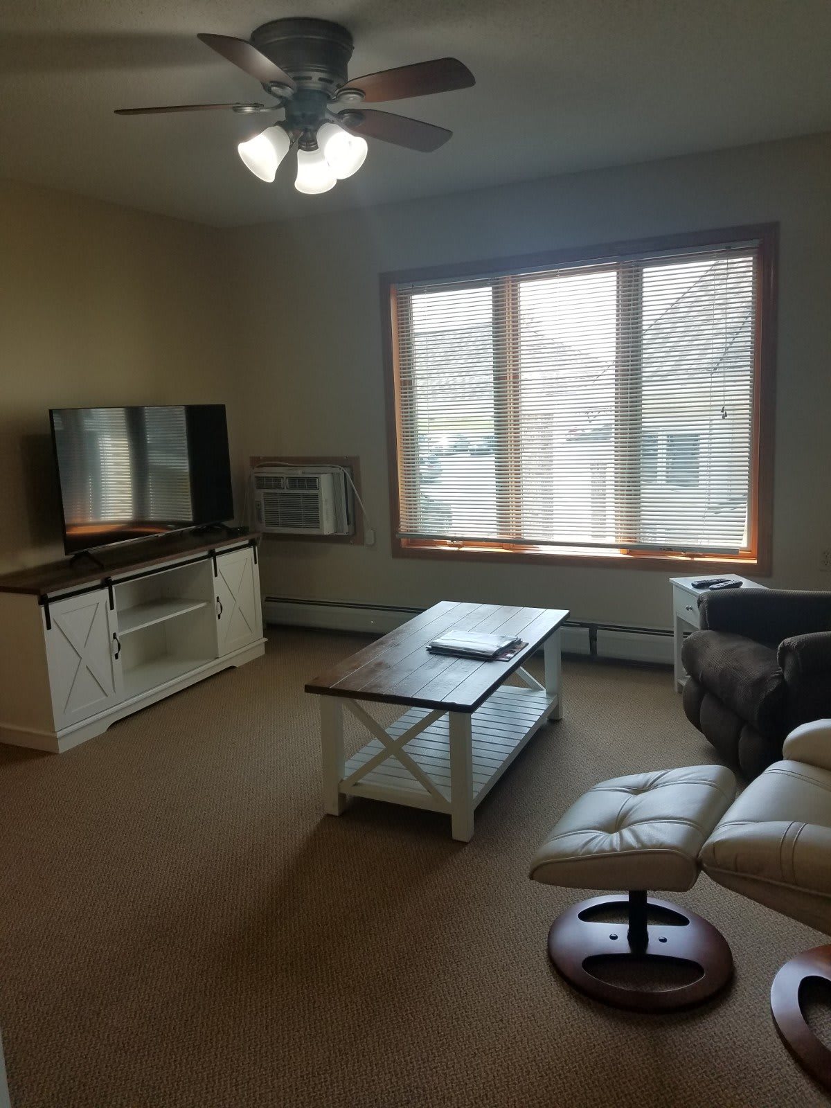 A cozy living room with a TV, coffee table, and comfortable seating.