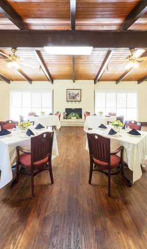 A beautifully arranged dining room featuring elegantly set tables and warm wooden accents.
