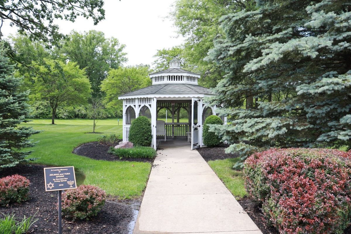 A picturesque gazebo surrounded by lush greenery and a well-maintained garden path.