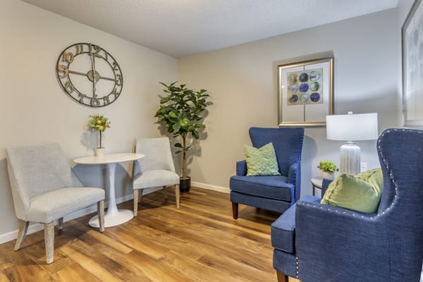 A cozy living room with stylish armchairs, a wooden floor, and tasteful decor.