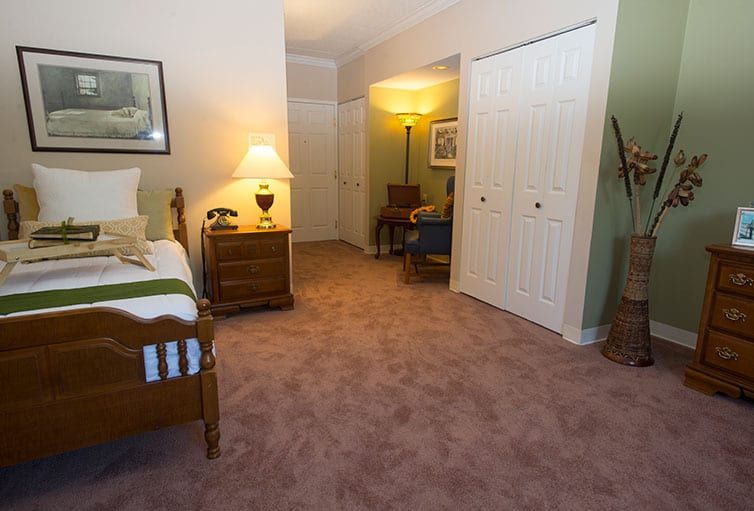 A cozy bedroom with warm lighting and carpeted floors.