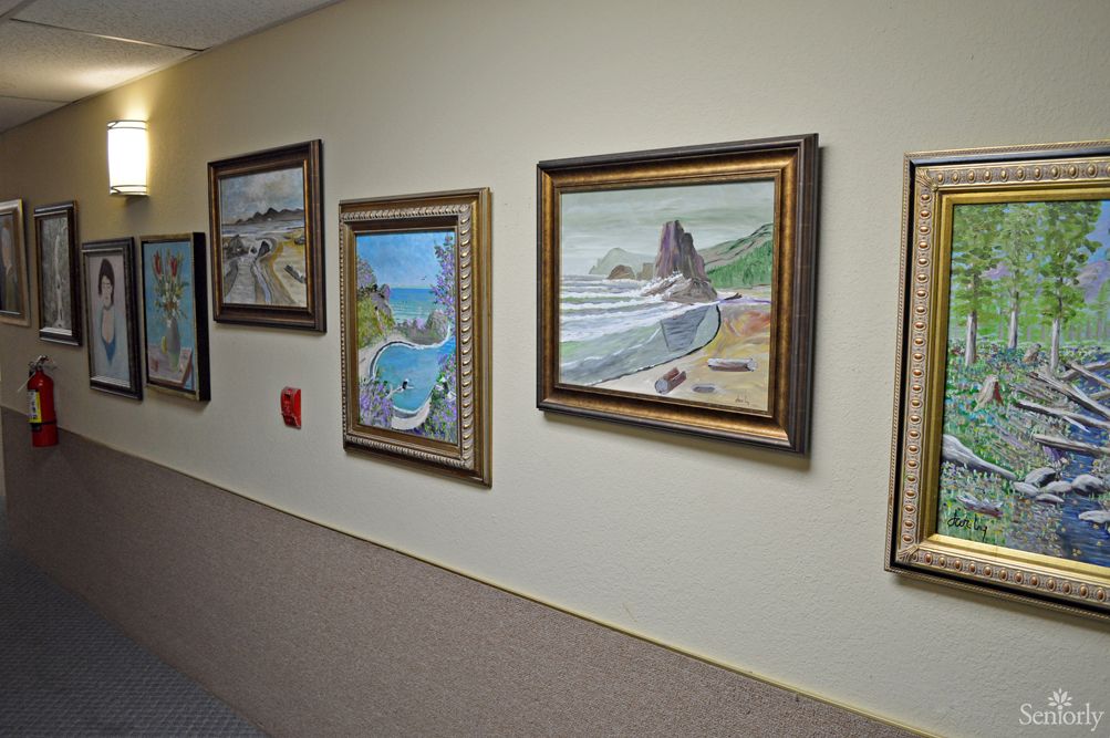 A hallway adorned with framed landscape paintings.