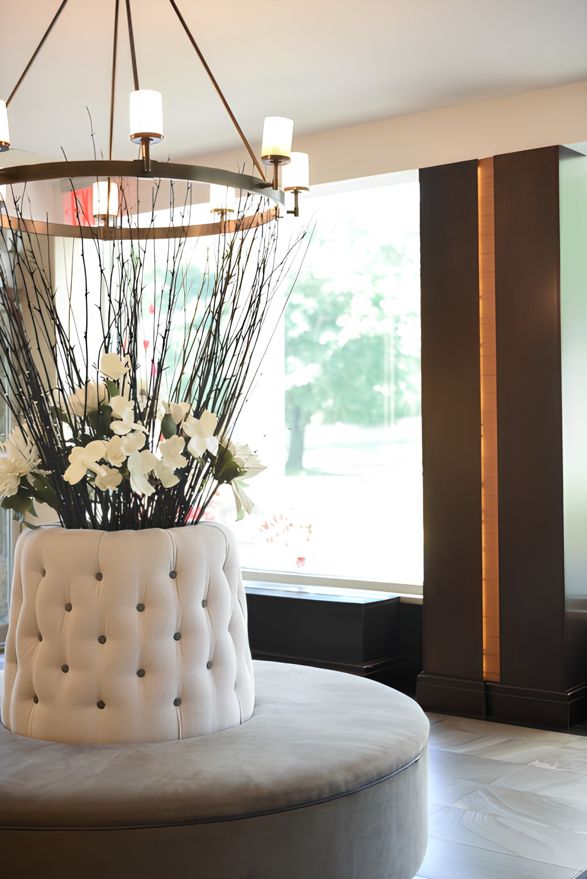 A luxurious lobby interior with a tufted seating area and elegant floral arrangement.