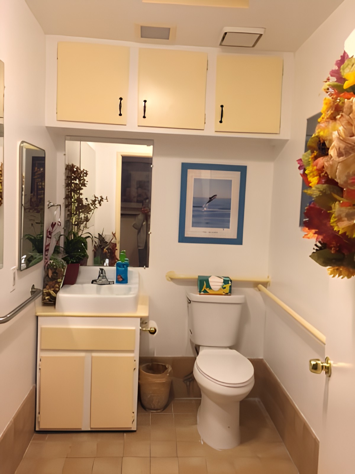 A small, cozy bathroom with a sink, toilet, and autumn-themed decorations.