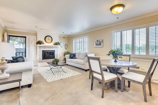 A cozy living and dining area featuring neutral tones, a fireplace, and elegant decor.