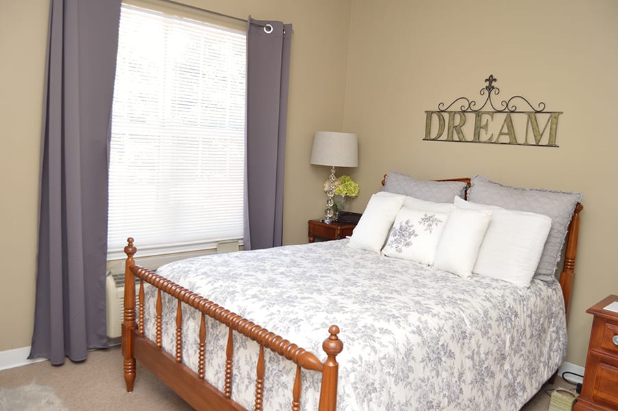 A cozy bedroom with a wooden bed frame and elegant decor.