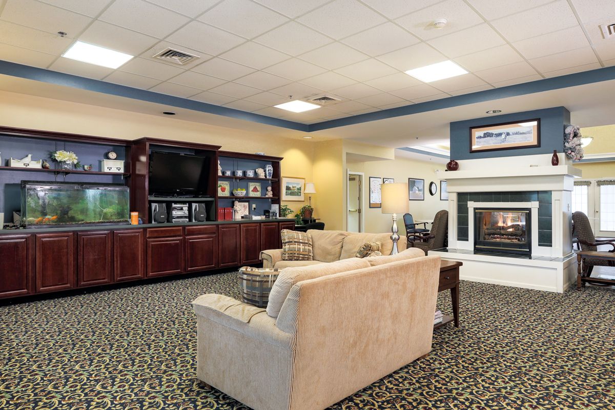 A cozy living room with a sofa, entertainment center, and fireplace.