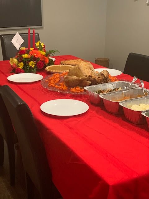 A festive Thanksgiving dinner table set with a turkey and various side dishes.