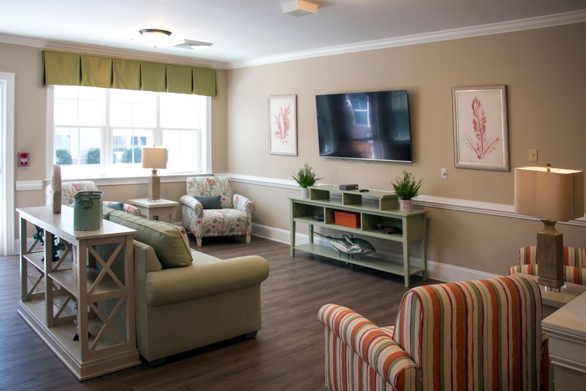 A cozy living room with comfortable seating, a wall-mounted TV, and tasteful decor.