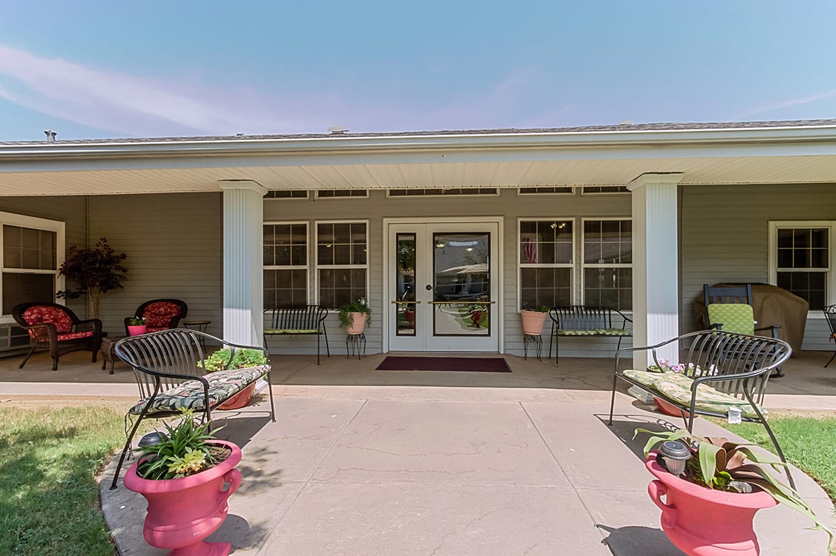 A welcoming entrance with columns, seating, and decorative planters.