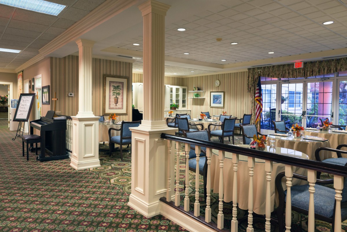 A cozy lounge area with seating, carpeted floor, and decorative columns.