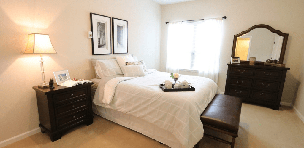 A minimalist bedroom with a neatly made bed and simple decor.