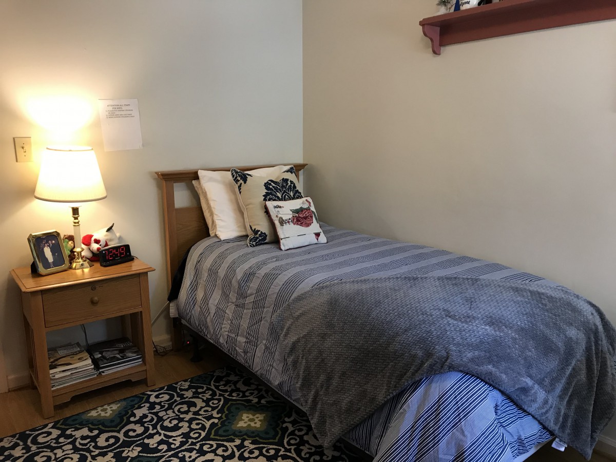 A cozy bedroom with a single bed, nightstand, and decorative elements.