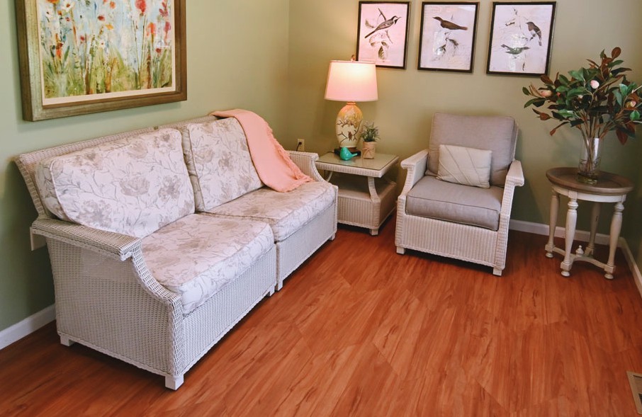 A cozy living room with a sofa, armchair, and decorative wall art.