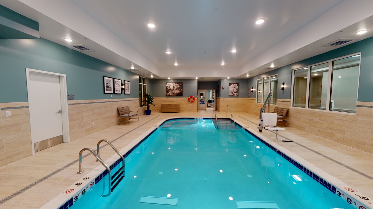An inviting indoor swimming pool with ambient lighting and seating areas.
