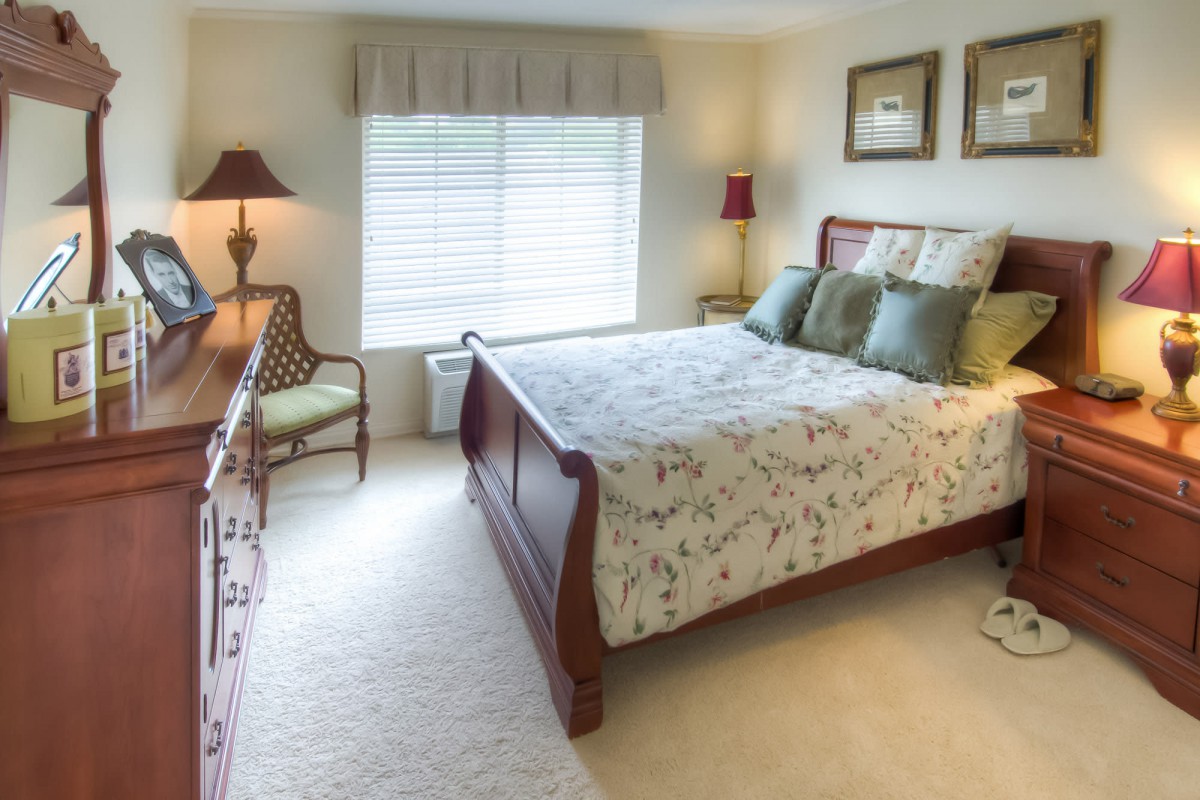 A cozy bedroom with classic wooden furniture and soft lighting.