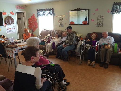 A group of elderly individuals gathered in a community center, enjoying each other's company in a cozy indoor setting.