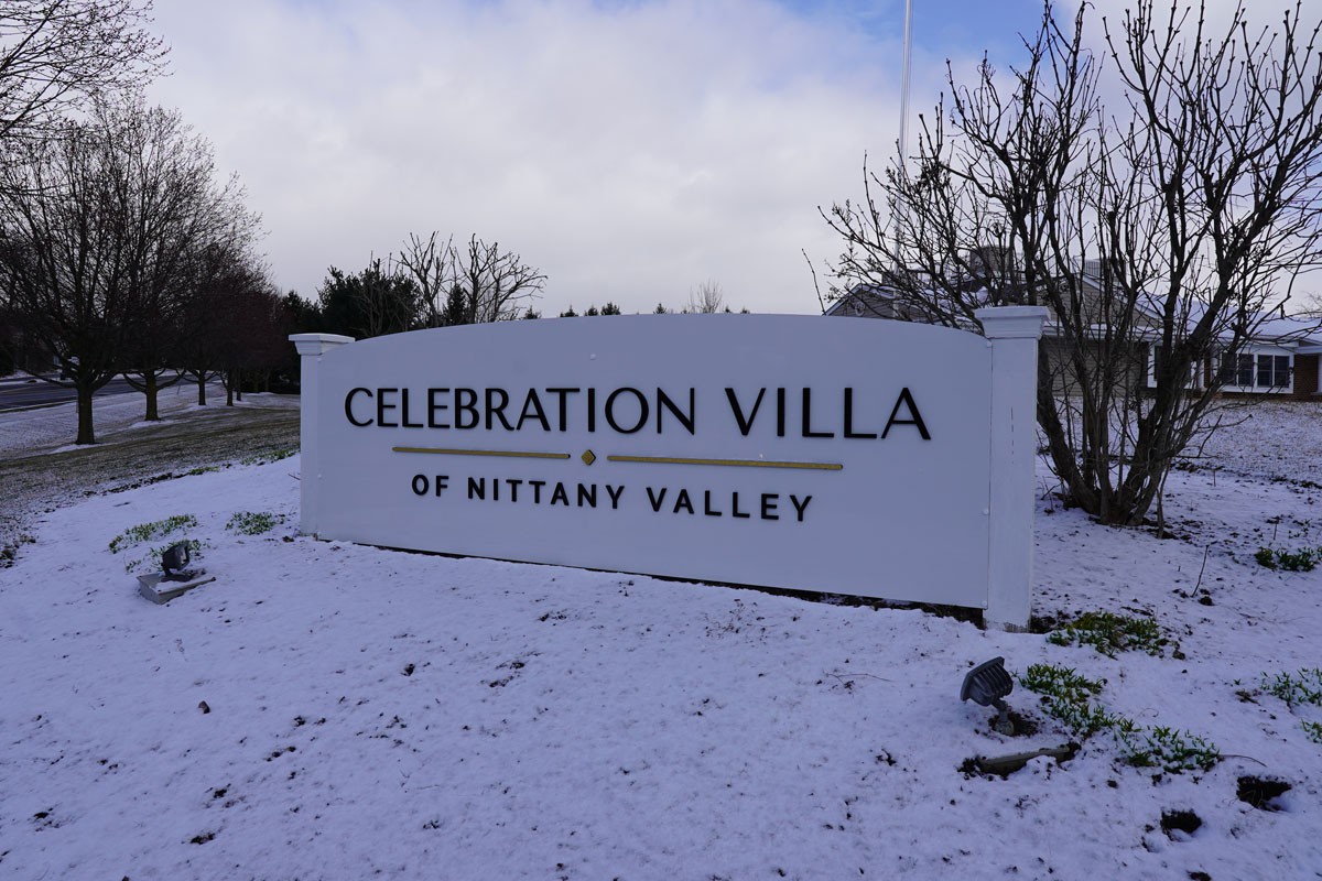 Sign for Celebration Villa of Nittany Valley surrounded by snow.