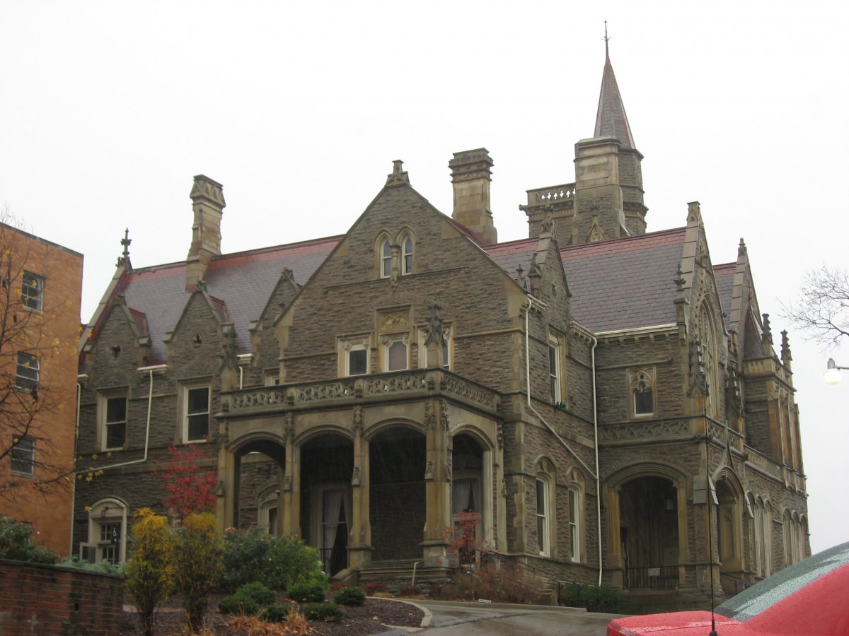 A historic Gothic-style mansion with intricate stone architecture and tall chimneys.