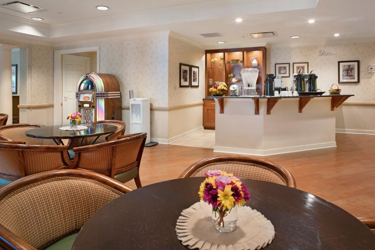 A cozy dining area featuring a vintage jukebox and fresh flowers on the table.