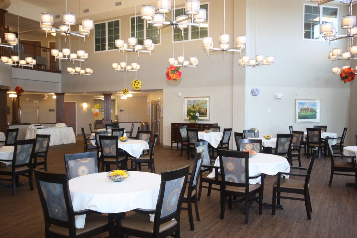 A well-lit dining area with elegantly arranged tables and chairs.
