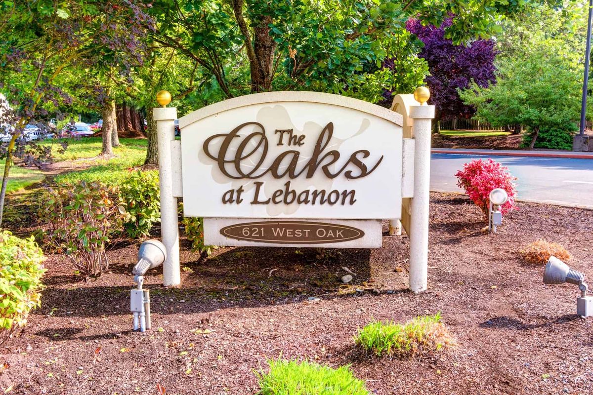 Entrance sign for The Oaks at Lebanon, surrounded by trees and landscaping.