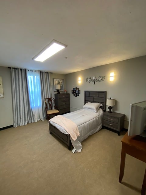 A cozy bedroom with a single bed, dresser, and neutral color scheme.
