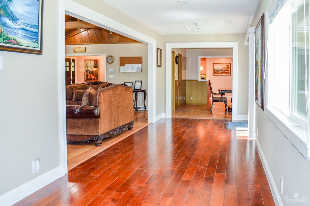 Spacious hallway with hardwood floors leading to a cozy living room.