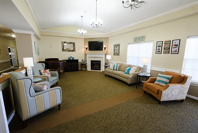 A cozy living room with comfortable seating, a fireplace, and a television.