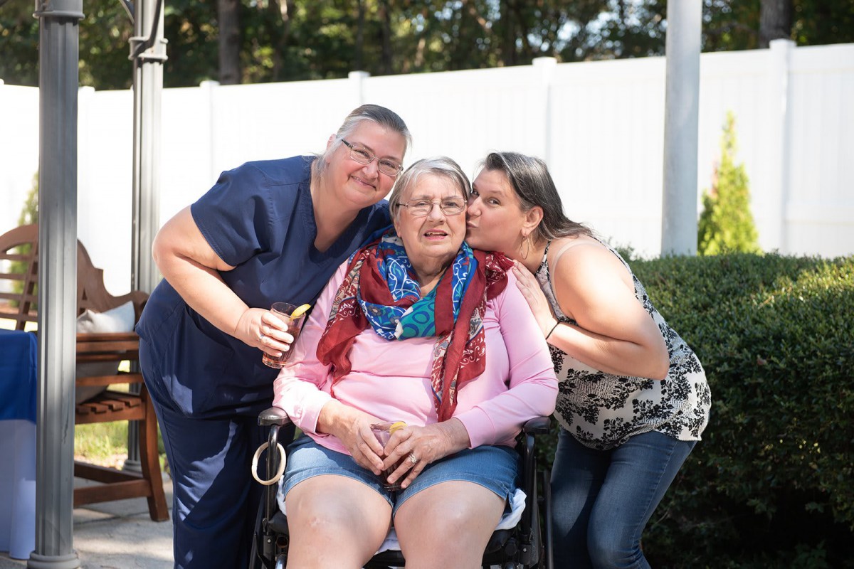 A heartwarming moment with family members showing love and support outdoors.