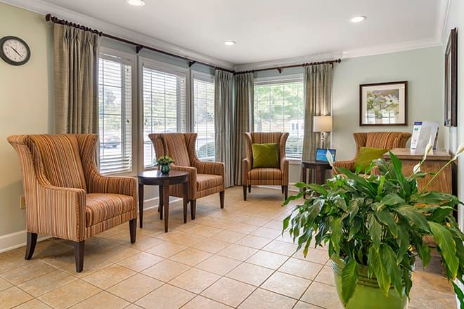 A comfortable waiting room with armchairs and natural lighting.