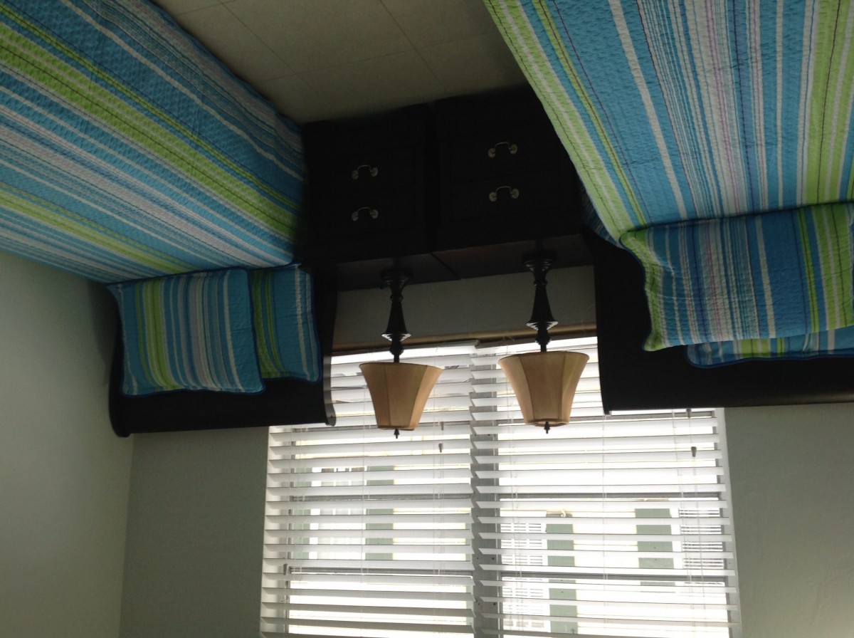 Interior view with striped fabric ceiling decor and window blinds.