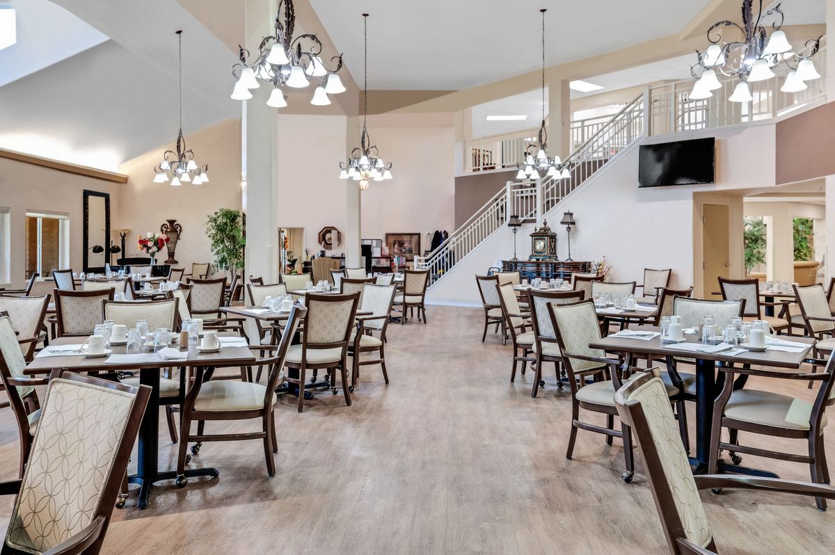 An elegant indoor dining area with neatly arranged tables and chairs, featuring stylish lighting fixtures.