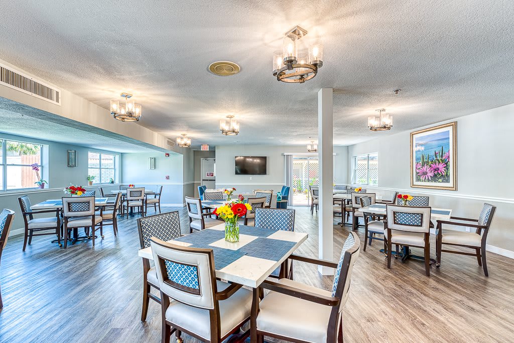 A modern and bright dining area with elegantly arranged tables and chairs.