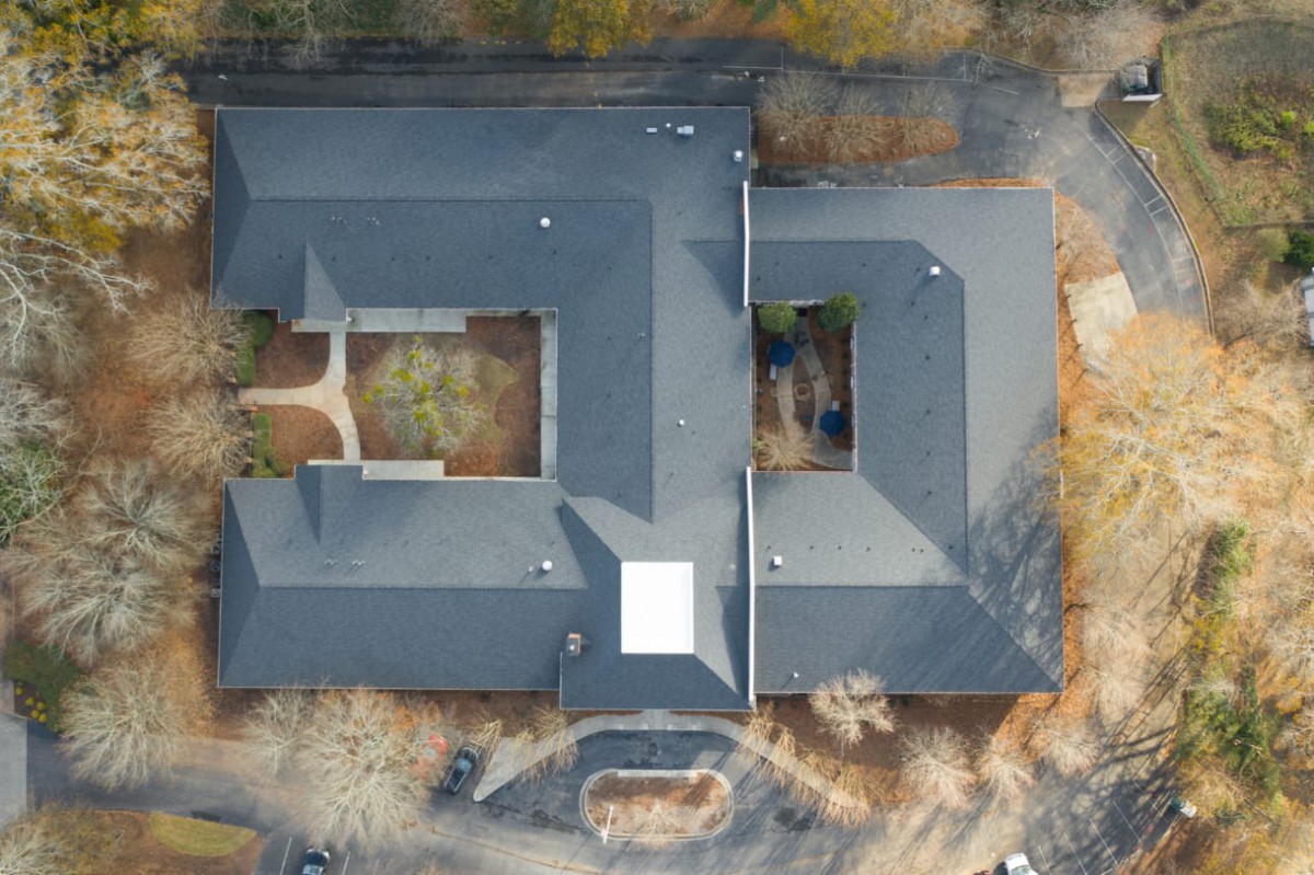 Aerial view of a large building with a central courtyard and complex roof design.